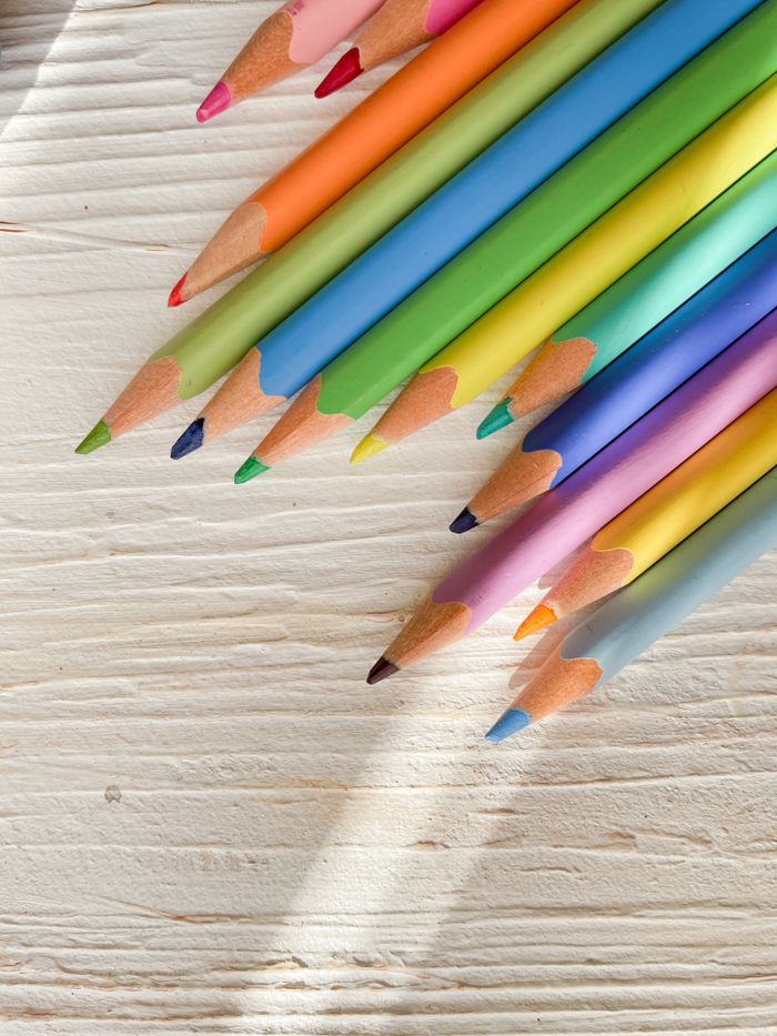 Vibrant colored pencils arranged diagonally on a wooden surface, perfect for artistic pursuits.